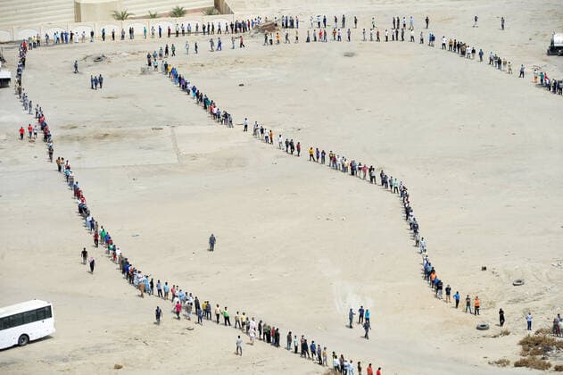(200411) -- AHMADI GOVERNORATE, April 11, 2020 (Xinhua) -- Residents of area of Mahboula queue up to receive food after the area was locked down by the government to curb the spread of novel coronavirus, in Ahmadi Governorate, Kuwait, April 11, 2020. The Kuwaiti government has decided to impose a complete lockdown on the areas of Mahboula and Jleeb Al-Shuyoukh for two weeks. Kuwait reported on Saturday 161 new COVID-19 cases, bringing the total number of confirmed cases in the country to 1,154, the Health Ministry said in a statement. (Photo by Asad Xinhua) KUWAIT-AHMADI GOVERNORATE-FOOD DISTRIBUTION 