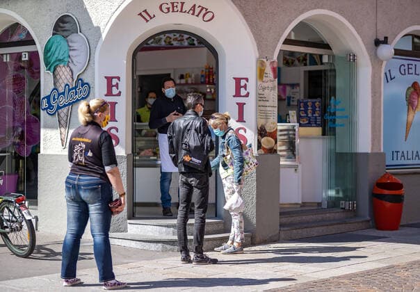 Lienz THEMENBILD - In Oesterreich gelten aufgrund der Covid-19-Pandemie Ausgangsbeschraenkungen, Betretungsverbote und andere Regelungen, die in das Alltagsleben eingreifen. Hier im Bild Kunden warten vor einer Eisdiele auf Ihre zuvor mittels Handy bestellten Eis. Lienz am Samstag 11. April 2019 In Austria, due to the Covid 19 pandemic, exit restrictions, entry bans and other regulations that affect everyday life apply. Here in the picture: Customers are waiting in front of an ice cream parlor for the ice cream they previously ordered using their mobile phone. Lienz on Saturday April 11, 2019.