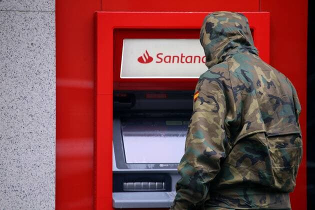 Spain: 29th day of alert status for CoVid-19 Gijon, SPAIN: A Spanish Army soldier cleans a Banco Santander ATM during the 29th day of the Spanish Alert State, in Gijon, Spain on April 11, 2020. Gijon Asturias Spain Copyright: AlbertoxBrevers