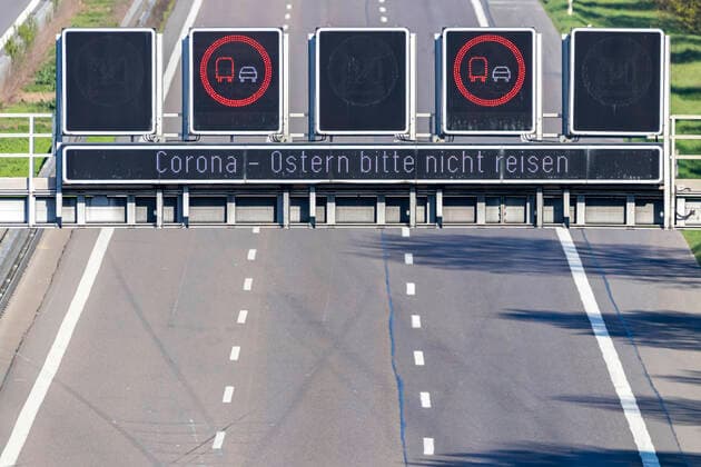 DEU, Deutschland, Baden-Württemberg, Stuttgart, 11.04.2020: Autobahn A8 bei Stuttgart in Zeiten der Corona-Pandemie. Es sind nur wenige Fahrzeuge unterwegs. Ein LED Wechselverkehrszeichen mahnt zum Kontaktverzicht: Corona - Ostern bitte nicht reisen.