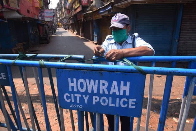(200411) -- KOLKATA, April 11, 2020 -- Security member secures a lane by tightening fences on the outskirts of Kolkata, India on April 11, 2020. (Str Xinhua) INDIA-KOLKATA-COVID-19-LOCKDOWN Stringer 