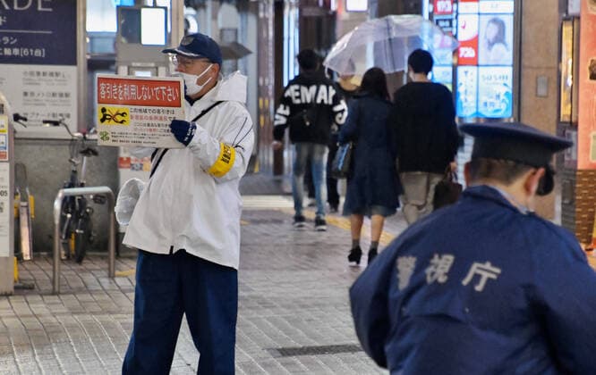 Officer of the Shinjuku ward asks for pedestrians to stay home on the street at Kabukicho shopping and entertainment district in Tokyo, Japan on Saturday evening on April 11, 2020.  TKP2020041126 KEIZOxMORI
