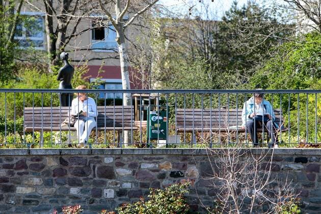 11.04.2020, xtgx, Auswirkungen des Corona Virus in Magdeburg, zwei Seniorinnen lesen mit grossem Abstand auf Parkbaenken Buecher Magdeburg