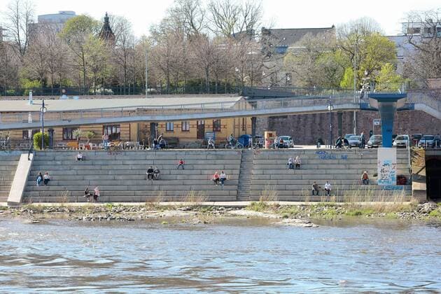 11.04.2020, xtgx, Auswirkungen des Corona Virus in Magdeburg, Menschen sitzen mit grossem Abstand auf den Treppen am Domfelsen, Symbolfoto, Symbolbild, Kontaktverbot, Abstand, Distanz, Social Distancing Magdeburg