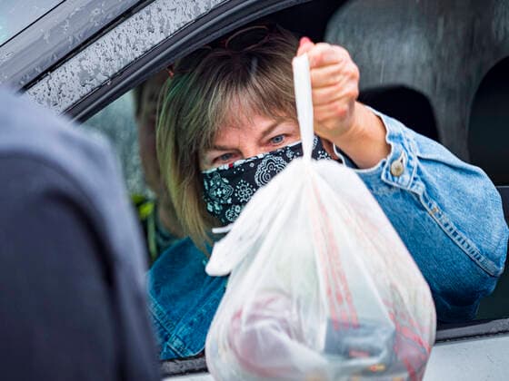 April 11, 2020, Des Moines, Iowa, U.S: A motorist picks a ready to cook pasta meal during a food distribution in Des Moines. Most non-essential businesses in Iowa are closed until 30 April. Because of business closings causes by the Novel Coronavirus (SARS-CoV-2) pandemic, well over 100,000 Iowans filed first time claims for unemployment in the last three weeks, more than applied during the peak of the Great Recession of 2008. Local food banks have seen an unprecedented spike in people seeking nutritional assistance. Midwest Foods, a Des Moines based company and owner of Ginos Fine Italian Foods, gave away 1,000 complete dinners with sauce, noodles, salad, and dressing Saturday morning. People started lining up 3 hours before the food distribution began. The food distribution was done following social distancing guidelines and all of - ZUMAk94_ 20200411_zaf_k94_017 Copyright: xJackxKurtzx