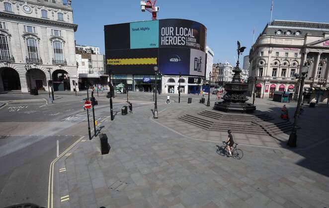 Day Nineteen of Lockdown in London. A person on a bike stops to look at the advertising board in Piccadilly Circus on Easter Saturday. It is the first public holiday of the year, and many people enjoy the long weekend by going out and about or on holiday, but this year the country is on lockdown due to the COVID-19 Coronavirus pandemic. People are not allowed to leave home except for minimal food shopping, medical treatment, exercise - once a day, and essential work. COVID-19 Coronavirus lockdown, London, UK, on April 11, 2020 