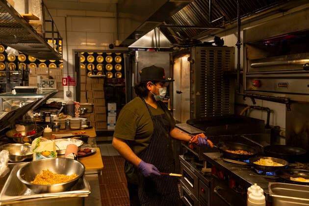 Struggling in NYC amid COVID-19 pandemic A cook prepares food at Beatstro restaurant amid COVID-19 pandemic for distribution by World Central Kitchen non-profit organization created by Jose Andres the world renowned chef. Food pantries have been opened in many poor neighborhoods of the city the most hit by epidemic New York New York United States Copyright: LevxRadin