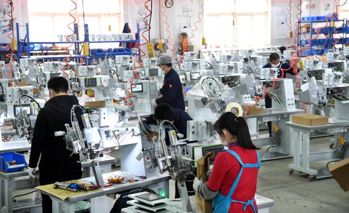 (200412) -- QINGDAO, April 12, 2020 -- Workers work overtime to produce seam sealing equipment for protective clothes at the workshop of Nawon Machinery Co., Ltd. in Jimo District of Qingdao, east China s Shandong Province, April 11, 2020. Since its resumption of production on Feb. 7, the South Korea-invested Nawon Machinery Co., Ltd. has been producing at full speed the seam sealing equipment for protective clothes, a necessary but not mass produced equipment which has been in short supply due to the worldwide spread of the COVID-19 pandemic. ) CHINA-QINGDAO-COVID-19-SOUTH KOREAN COMPANY-SEAM SEALING EQUIPMENT-PRODUCTION (CN) LixZiheng 