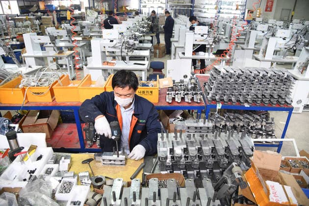 (200412) -- QINGDAO, April 12, 2020 -- Workers work overtime to produce seam sealing equipment for protective clothes at the workshop of Nawon Machinery Co., Ltd. in Jimo District of Qingdao, east China s Shandong Province, April 11, 2020. Since its resumption of production on Feb. 7, the South Korea-invested Nawon Machinery Co., Ltd. has been producing at full speed the seam sealing equipment for protective clothes, a necessary but not mass produced equipment which has been in short supply due to the worldwide spread of the COVID-19 pandemic. ) CHINA-QINGDAO-COVID-19-SOUTH KOREAN COMPANY-SEAM SEALING EQUIPMENT-PRODUCTION (CN) LixZiheng 