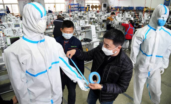 (200412) -- QINGDAO, April 12, 2020 -- Han Chuqi (R), head of the Nawon Machinery Co., Ltd., examines the quality of the bands for protective clothes at the workshop of the company in Jimo District of Qingdao, east China s Shandong Province, April 11, 2020. Since its resumption of production on Feb. 7, the South Korea-invested Nawon Machinery Co., Ltd. has been producing at full speed the seam sealing equipment for protective clothes, a necessary but not mass produced equipment which has been in short supply due to the worldwide spread of the COVID-19 pandemic. ) CHINA-QINGDAO-COVID-19-SOUTH KOREAN COMPANY-SEAM SEALING EQUIPMENT-PRODUCTION (CN) LixZiheng