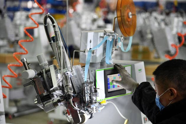 (200412) -- QINGDAO, April 12, 2020 -- A worker configures the system of the seam sealing equipment for protective clothes at the workshop of Nawon Machinery Co., Ltd. in Jimo District of Qingdao, east China s Shandong Province, April 11, 2020. Since its resumption of production on Feb. 7, the South Korea-invested Nawon Machinery Co., Ltd. has been producing at full speed the seam sealing equipment for protective clothes, a necessary but not mass produced equipment which has been in short supply due to the worldwide spread of the COVID-19 pandemic. ) CHINA-QINGDAO-COVID-19-SOUTH KOREAN COMPANY-SEAM SEALING EQUIPMENT-PRODUCTION (CN) LixZiheng 