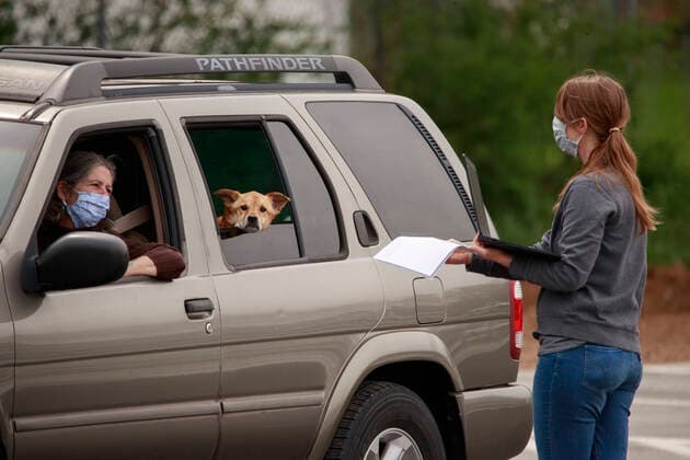 April 11, 2020, Bloomington, Indiana, United States: A woman wearing a face mask, right, talks to a customer at the Bloomington Community Farmers Market, where food is being distributed in a drive-thru arrangement by the first letter of people s last names at the Switchyard Pavilion. Bloomington United States - ZUMAs197 20200411_zaa_s197_178 Copyright: xJeremyxHoganx
