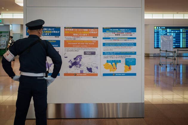 Coronavirus in Japan, Eindrücke vom Flughafen Tokio-Haneda A security guard looks at poster showing where the corona virus crisis is high on the arrivals floor at Tokyo International Airport at Haneda in Tokyo, Japan, 12 April 2020. Japanese Prime Minister Shinzo Abe declared a state of emergency for at least one month amid an increase of coronavirus and COVID-19 infection cases. April 12, 2020  (125267507)