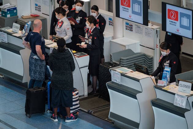 Coronavirus in Japan, Eindrücke vom Flughafen Tokio-Haneda JAL Lines ground staff wearing mask talk with customers at counters on the departures floor at Tokyo International Airport at Haneda in Tokyo, Japan, 12 April 2020. Japanese Prime Minister Shinzo Abe declared a state of emergency for at least one month amid an increase of coronavirus and COVID-19 infection cases. April 12, 2020  (125267574)