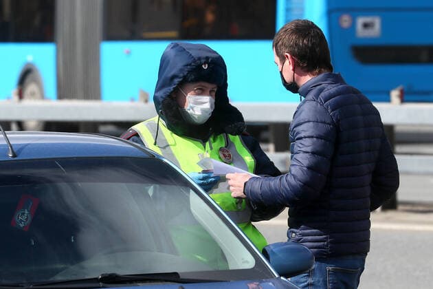 MOSCOW, RUSSIA - APRIL 12, 2020: A road police officer at an entrance to Moscow in Leninsky Prospekt Street. Police do not let cars registered in other regions, except for the Moscow Region, to enter the city as part of the measures to counter the spread of the COVID-19 coronavirus. Alexander Shcherbak TASS  TS0D563B
