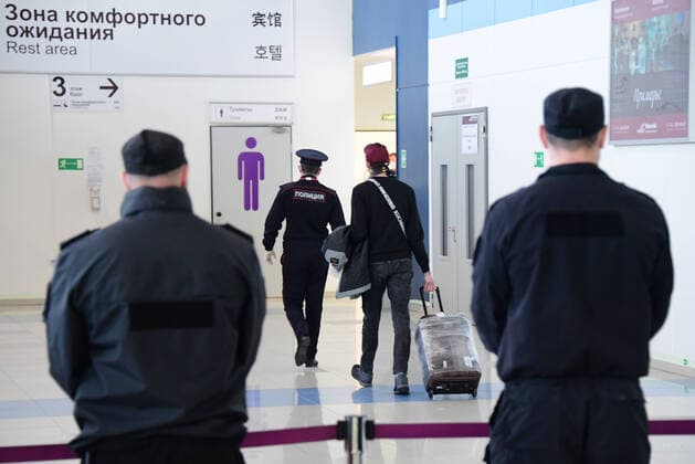 VLADIVOSTOK, RUSSIA - APRIL 12, 2020: A Russian citizen who has arrived from Seoul and a police officer at Vladivostok International Airport. Russia has suspended all international flights from March 27, 2020 due to the COVID-19 infection threat. Airlines are allowed to fly to other countries to evacuate Russian citizens. Yuri Smityuk TASS  TS0D56A0