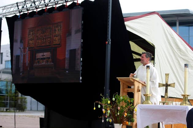 Erfurt, 12.04.2020 Pfarrer Christoph Knoll von der Thomasgemeinde Erfurt hält den Auto-Ostergottesdienst am Ostersonntag auf dem Gelände der Erfurter Messe. Wegen der Coronakrise düfen zur zeit keine Gottesdienste in Kirchen abgehalten werden. Die Stadt Erfurt hat diese Art von Gottesdienst genehmigt, weil es sich bei einem Auto um einen geschlossenen Raum handelt in dem maximal 2 Persone sitzen durften und so dei Abstandregel eingehalten werden.