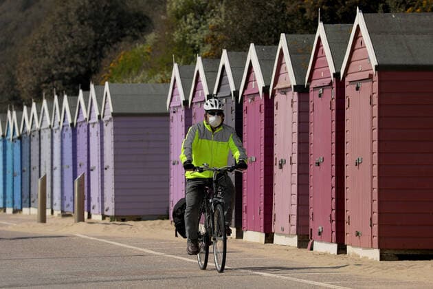 (200412) -- BOURNEMOUTH, April 12, 2020 (Xinhua) -- A man cycles past beach huts on Bournemouth Beach in Bournemouth, Britain on April 11, 2020. (Photo by Tim Ireland Xinhua) BRITAIN-BOURNEMOUTH-COVID-19-BEACH 