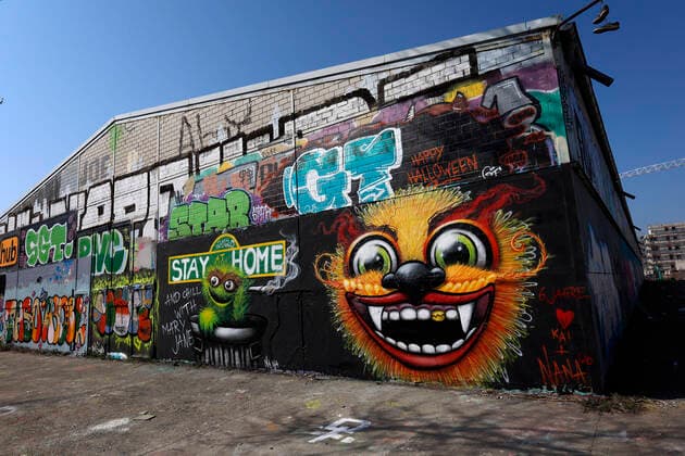 Duesseldorf, Deutschland, 12.04.2020 Das Graffiti Wandbild an der Aussenwand einer Lagerhalle in Duesseldorf - Moersenbroich verwendet den Slogan zuhause zu bleiben ( Stay at Home ) mit der gleichzeitigen Empfehlung dort mit einem Joint zu entspannen ( Chill with Mary Jane )