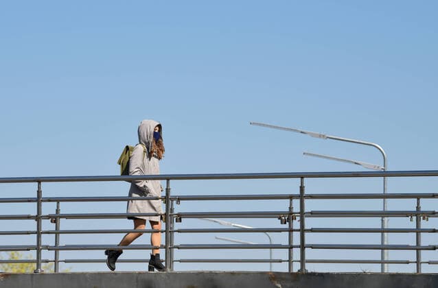 April 12, 2020, Kiev, Ukraine: A woman wearing a face mask as a preventive measure against the spread of coronavirus walks along the pedestrians bridge..Due to the outbreak of the coronavirus COVID-19, the Kiev-Pechersk Lavra is quarantined. They disinfected the premises and closed the church for believers. Kiev Ukraine - ZUMAs197 20200412_zaa_s197_105 Copyright: xMaksymxPolishchukx