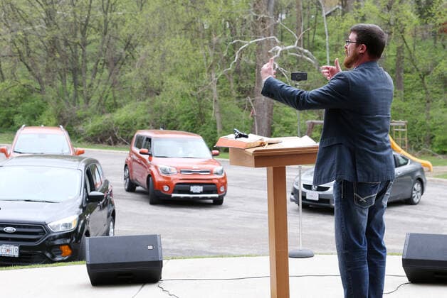 Pastor Justin Arender delivers his Easter Service to the faithful at the Faith Baptist Church in St. Charles, Missouri on Sunday, April 12, 2020. The church held a parking lot service, keeping parishioners in their cars, listening to music and a sermon, honking their horns for approval.  SLP2020041221 BILLxGREENBLATT