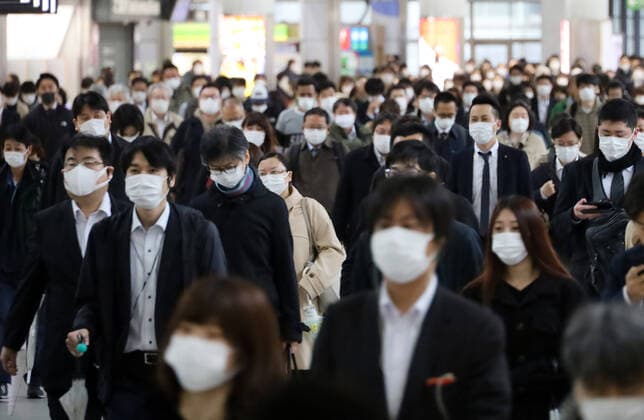 April 13, 2020, Tokyo, Japan - Commueters walk to their office in Tokyo on Monday, April 13, 2020. Japanese government asked to reduce person-to-person contact by up to 80 percent as Prime Minister Shinzo Abe declared a state of emergency to fight the new coronavirus.  (125288267)
