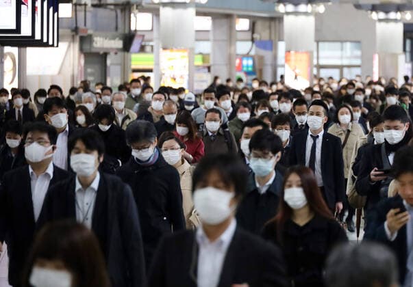 April 13, 2020, Tokyo, Japan - Commueters walk to their office in Tokyo on Monday, April 13, 2020. Japanese government asked to reduce person-to-person contact by up to 80 percent as Prime Minister Shinzo Abe declared a state of emergency to fight the new coronavirus.  (125288289)