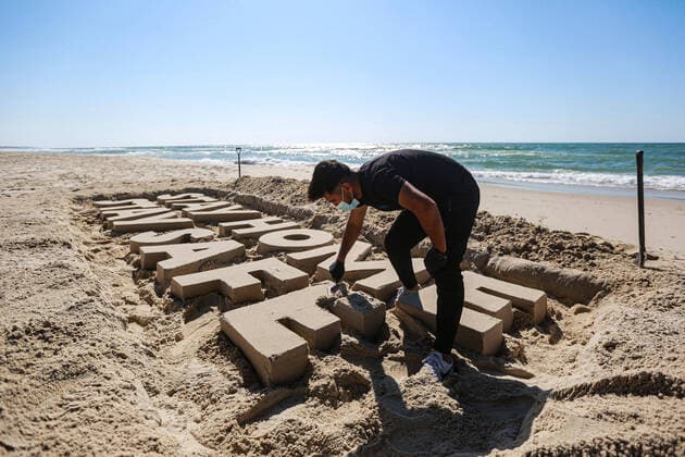 (200412) -- GAZA, April 12, 2020 (Xinhua) -- A Palestinian artist carves words STAY HOME STAY SAFE with sand on a beach in Gaza City, on April 12, 2020. Palestine said on Sunday that the total number of COVID-19 cases in the country has reached 290. (Photo by Rizek Abdeljawad Xinhua) MIDEAST-GAZA CITY-COVID-19-SAND ART 