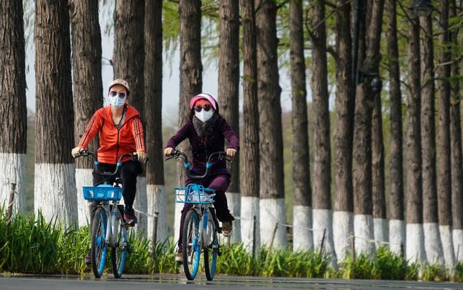 (200413) -- WUHAN, April 13, 2020 -- People ride bikes on the road of Donghu greenway in Wuhan, central China s Hubei Province, April 13, 2020. As the coronavirus epidemic wanes, more and more people come to Donghu greenway to enjoy the spring. ) CHINA-HUBEI-WUHAN-GREENWAY (CN) ChengxMin 