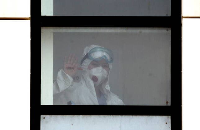 MOSCOW, RUSSIA - APRIL 13, 2020: A medical worker in protective gear in a window of the Novomoskovsky multipurpose medical center for patients with suspected COVID-19 coronavirus infection. Valery Sharifulin TASS  TS0D58FE
