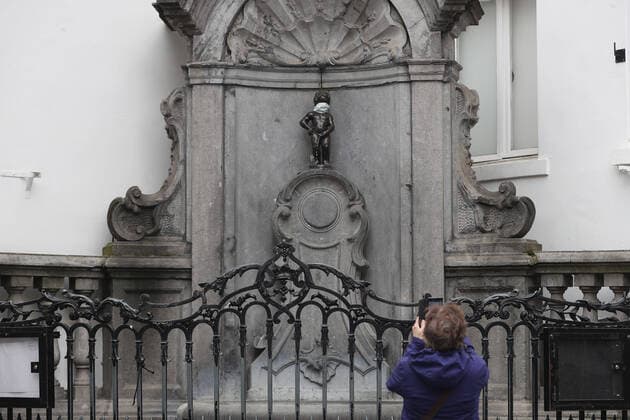 (200413) -- BRUSSELS, April 13, 2020 -- A woman takes photos of the Manneken Pis (Little Pissing Man) wearing a mask in Brussels, Belgium, April 13, 2020. The number of confirmed COVID-19 cases in Belgium has increased from 29,647 to 30,589 by Monday morning with 3,903 deaths, according to the latest figures from Belgian health authorities. ) BELGIUM-BRUSSELS-CORONAVIRUS ZhengxHuansong 