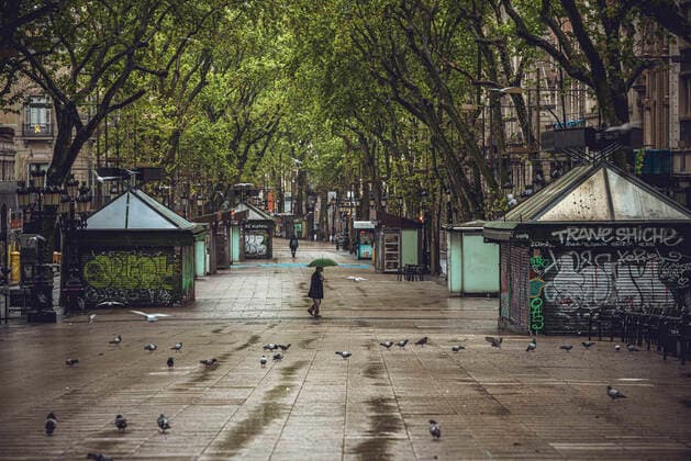 April 13, 2020, Barcelona, Catalonia, Spain: A commuter crosses Barcelona s rainy deserted Rambla at Easter Monday after more than one month of a nationwide lockdown due to the continuous spread of the virus. Spain registered roughly 300 new fatalities summing up to nearly 17500 in total. Barcelona Spain - ZUMAo105 20200413_zap_o105_003 Copyright: xMatthiasxOesterlex