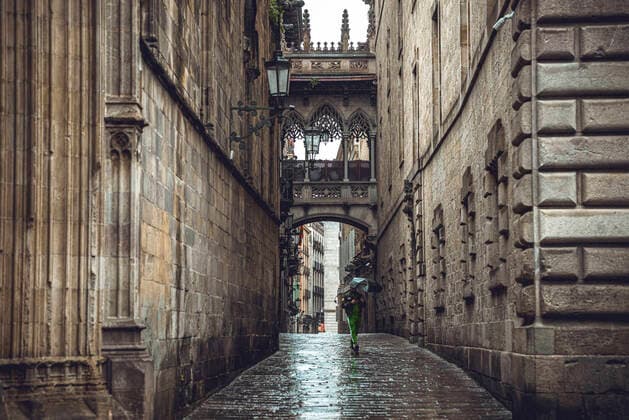 April 13, 2020, Barcelona, Catalonia, Spain: A commuter crosses Barcelona s rainy deserted Gothic Quarter at Easter Monday after more than one month of a nationwide lockdown due to the continuous spread of the virus. Spain registered roughly 300 new fatalities summing up to nearly 17500 in total. Barcelona Spain - ZUMAo105 20200413_zap_o105_006 Copyright: xMatthiasxOesterlex