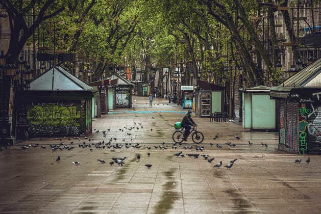 April 13, 2020, Barcelona, Catalonia, Spain: A commuter crosses Barcelona s rainy deserted Rambla at Easter Monday after more than one month of a nationwide lockdown due to the continuous spread of the virus. Spain registered roughly 300 new fatalities summing up to nearly 17500 in total. Barcelona Spain - ZUMAo105 20200413_zap_o105_005 Copyright: xMatthiasxOesterlex