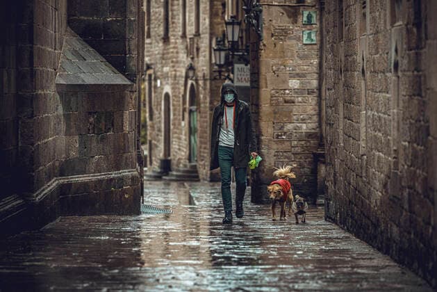 April 13, 2020, Barcelona, Catalonia, Spain: A commuter crosses Barcelona s rainy deserted Gothic Quarter at Easter Monday after more than one month of a nationwide lockdown due to the continuous spread of the virus. Spain registered roughly 300 new fatalities summing up to nearly 17500 in total. Barcelona Spain - ZUMAo105 20200413_zap_o105_008 Copyright: xMatthiasxOesterlex