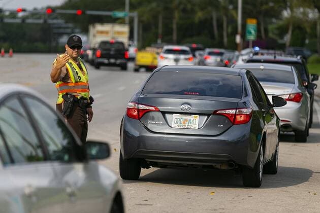 April 13, 2020, Miami, Fl, USA: Police direct traffic as cars arrive to a COVID-19 drive-thru testing center near the Hard Rock Stadium in Miami Gardens, Florida on Monday, April 13, 2020. The Florida Army National Guard set up the center and is now expanding its testing criteria to include anyone with COVID-19 symptoms. Miami USA - ZUMAm67_ 20200413_zaf_m67_020 Copyright: xMatiasxJ.xOcnerx