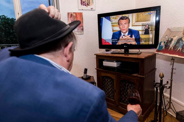 Chambery, France April 13, 2020 - A A confined French man in watching on television the speech of the French President Emmanuel Macron concerning the COVID19 health crisis ALLOCUTION, MACRON, PRESIDENT DE LA REPUBLIQUE, DISCOURS, COVID19, CRISE SANITAIRE, CONFINEMENT, SANTE, CORONAVIRUS, POLITIQUE  Copyright: xVincentxIsorex