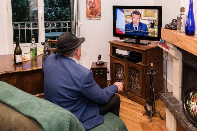 Chambery, France April 13, 2020 - A A confined French man in watching on television the speech of the French President Emmanuel Macron concerning the COVID19 health crisis ALLOCUTION, MACRON, PRESIDENT DE LA REPUBLIQUE, DISCOURS, COVID19, CRISE SANITAIRE, CONFINEMENT, SANTE, CORONAVIRUS, POLITIQUE  Copyright: xVincentxIsorex