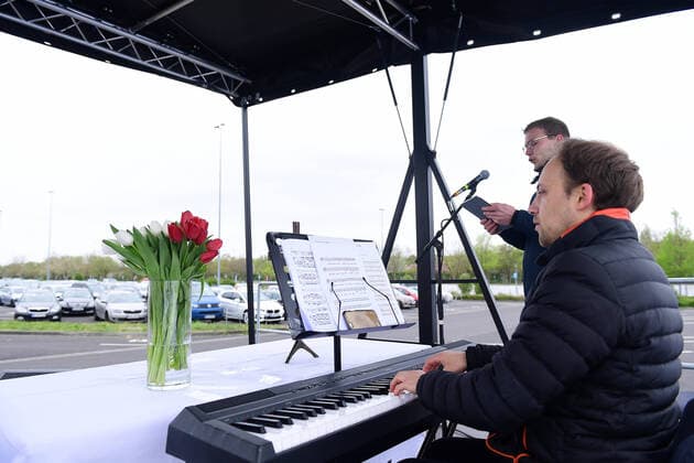 Ostergottesdienst im Autokino am 13.04.2020 in Düsseldorf Durch den evangelischen Gottesdienst führt Pfarrer Heinrich Fucks. Der Altar befindet sich auf einem Lastwagen, der vor der Leinwand des Autokinos positioniert wurde. Die Predigt des Pfarrers wird über das Audiosystem des Autokinos in die Radios der teilnehmenden Fahrzeuge übertragen. Das Düsseldorfer Autokino wurde als Reaktion auf die Schließung von Kinos im Zuge der Corona-Pandemie aufgebaut.