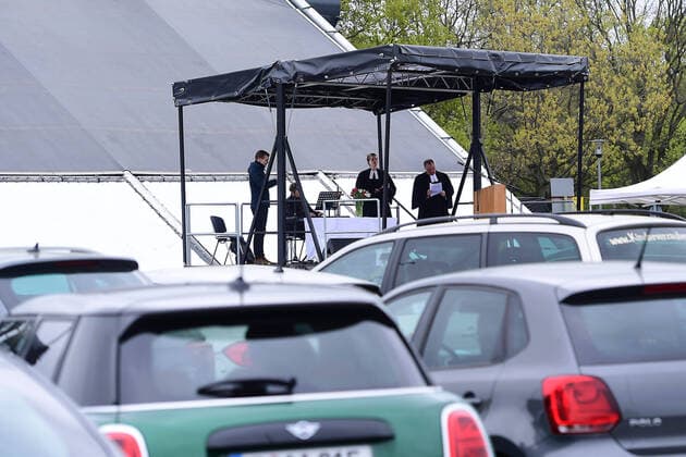 Ostergottesdienst im Autokino am 13.04.2020 in Düsseldorf Durch den evangelischen Gottesdienst führt Pfarrer Heinrich Fucks. Der Altar befindet sich auf einem Lastwagen, der vor der Leinwand des Autokinos positioniert wurde. Die Predigt des Pfarrers wird über das Audiosystem des Autokinos in die Radios der teilnehmenden Fahrzeuge übertragen. Das Düsseldorfer Autokino wurde als Reaktion auf die Schließung von Kinos im Zuge der Corona-Pandemie aufgebaut.