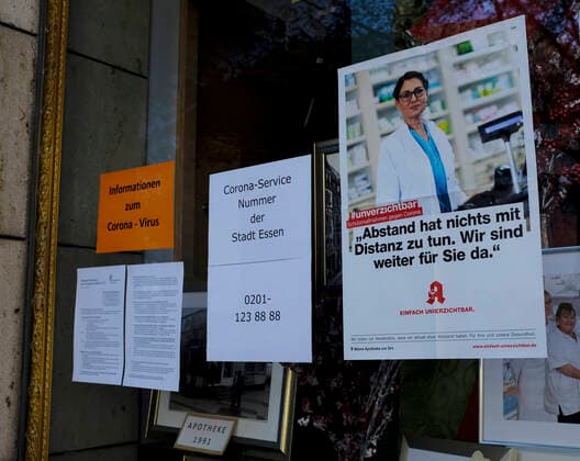 CORONA-PANDEMIE,CORONAVIRUS,COVID-19,Hinweisschild mit der Aufschrift unverzichtbar Schutzmaßnahmen gegen Corona.Abstand hat nichts mit Distanz zu tun.Wir sind weiter für sie da,fotografiert am 13.04.2020 im Schaufenster einer Apotheke in der Stadt Essen im Ruhrgebiet im Bundesland Nordrhein-Westfalen ( NRW ). Â