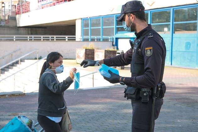 A police officer gives out free protective face masks during the lockdown amid the coronavirus disease COVID 19 outbreak in Madrid, Spain, April 13, 2020 Cordon Press