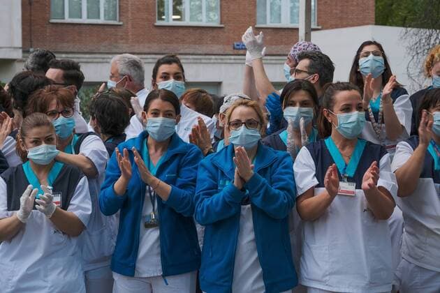 Medical staff from the Fundacion Jimenez Diaz Hospital gestures as neighbours applaud from their balconies in support of healthcare workers, during the coronavirus disease COVID 19 outbreak in Madrid, Spain April 13, 2020 Cordon Press