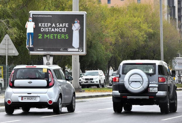 (200414) -- DOHA, April 14, 2020 (Xinhua) -- Vehicles pass by a COVID-19 awareness billboard in Doha, capital of Qatar, April 13, 2020. (Photo by Nikku Xinhua) QATAR-DOHA-COVID-19 