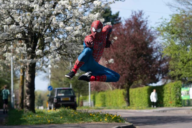 (200414) -- MANCHESTER, April 14, 2020 (Xinhua) -- Jason Baird, who runs a martial arts academy in South Manchester, dressed up as Spider-Man, entertains the public amid the COVID-19 outbreak in Manchester, Britain on April 13, 2020. (Photo by Jon Super Xinhua) BRITAIN-MANCHESTER-COVID-19-SPIDER-MAN 