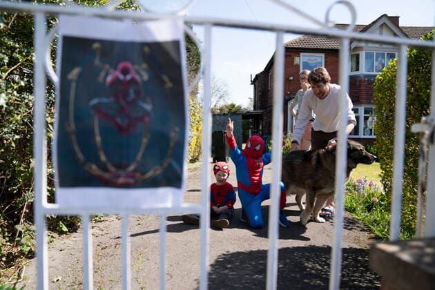 (200414) -- MANCHESTER, April 14, 2020 (Xinhua) -- Children wait for Jason Baird, who runs a martial arts academy in South Manchester, dressed up as Spider-Man to entertain the public amid the COVID-19 outbreak in Manchester, Britain on April 13, 2020. (Photo by Jon Super Xinhua) BRITAIN-MANCHESTER-COVID-19-SPIDER-MAN 