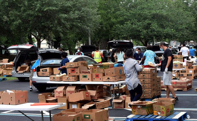 April 13, 2020, Orlando, Florida, United States: Volunteers from Church in the Son place food from the Second Harvest Food Bank of Central Florida into the cars of needy families at a drive-thru event..The numbers of people seeking food assistance in the Orlando area have risen sharply due to job losses caused by the coronavirus pandemic, thereby placing an extra burden on local food pantries. Orlando United States - ZUMAs197 20200413_zaa_s197_295 Copyright: xPaulxHennessyx