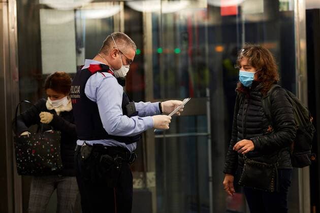 Mossos d Esquadra police officer (L) checks the working permit of commuters at a subway station in Barcelona, northeastern Spain, 14 April 2020. Central government decided that some non-essential economic activities resume its work from 13 April after two weeks amid the lockdown caused by coronavirus outbreak. Coronavirus crisis !ACHTUNG: NUR REDAKTIONELLE NUTZUNG!  Copyright: xAlejandroxGarciax GRAFCAT4850 20200414-637224595148665990
