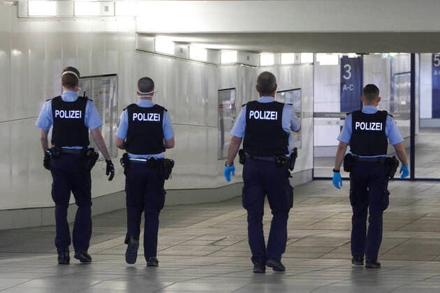 Eine Gruppe Polizeibeamter eilen zu einem Einsatz im Hauptbahnhof Würzburg, Bayern, Deutschland