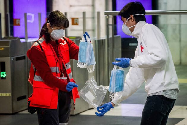 April 14, 2020, Barcelona, Catalonia, Spain: Red Cross volunteers hold protective face masks to distribute among commuters at Catalunya station in Barcelona. Thousands of people are returning to work after the Spanish government has lift the strictest measures of coronavirus confinement. Barcelona Spain - ZUMAb137 20200414_zap_b137_009 Copyright: xJordixBoixareux
